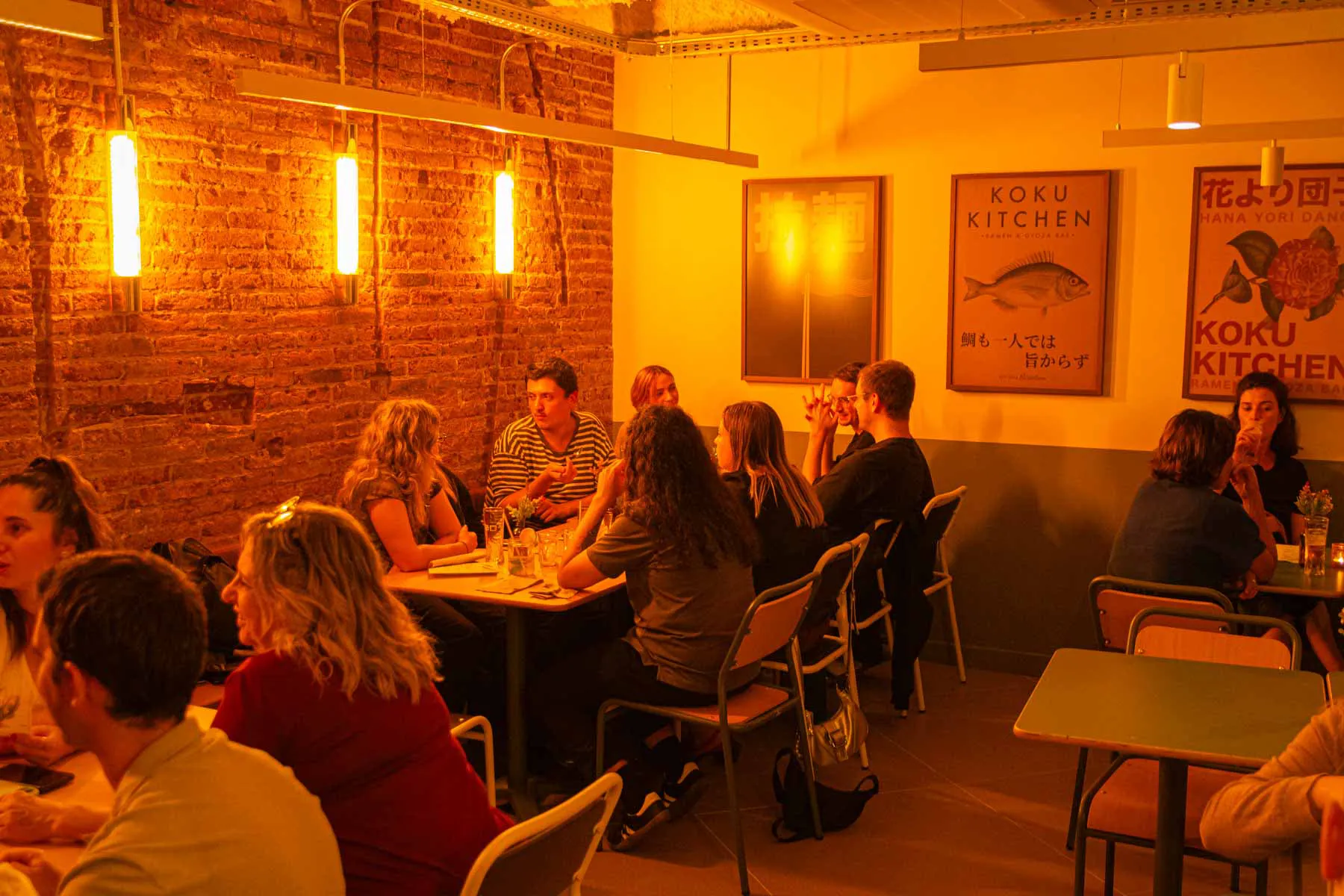 Brick walls and warm light in the dining room of Koku Kitchen Sant Antoni
