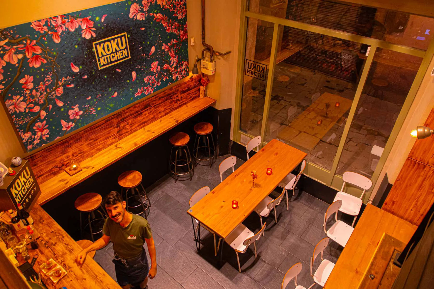 The wooden bar and high tables of Koku Kitchen El Gòtic, seen from above